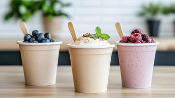 Three smoothies in paper cups with spoons photo