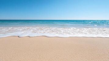 A beach with a clear blue sky and a wave photo
