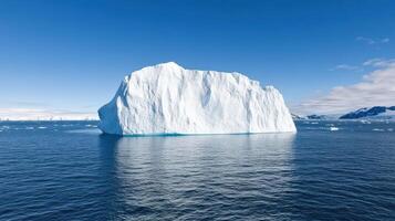 An iceberg floating in the ocean with blue sky photo