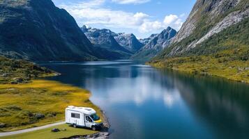 A camper is parked on the side of a mountain lake photo