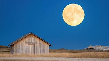 A barn with a full moon in the sky photo