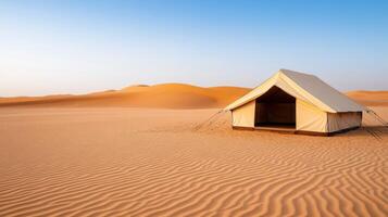 A tent in the desert with sand dunes and blue sky photo