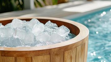 A wooden bucket filled with ice sitting next to a pool photo
