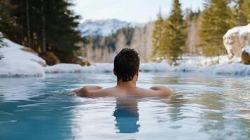 A man in a hot tub in the snow photo