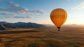 A yellow hot air balloon flying over a plain photo