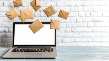 Email marketing concept with laptop and envelopes on wooden table photo