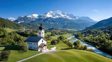 A church sits on a hill overlooking a valley and mountains photo
