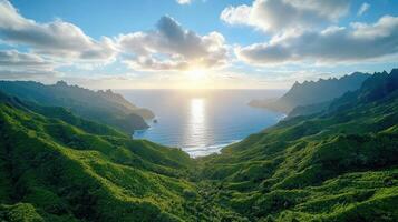 The sun sets over the ocean and green hills in hawaii photo