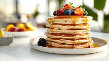 A stack of pancakes with syrup and berries photo