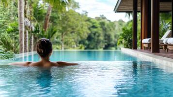 A woman relaxing in the pool at a resort photo