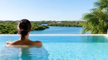 A woman relaxing in a pool overlooking a lake photo