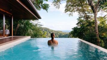 A woman is sitting in the pool of a luxury resort photo