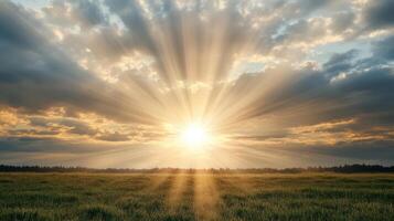 The sun shines through the clouds over a field photo