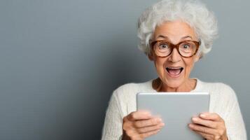 An older woman with glasses and a tablet computer photo