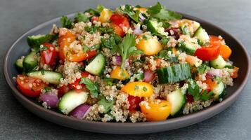 A bowl of quinoa salad with vegetables and herbs photo
