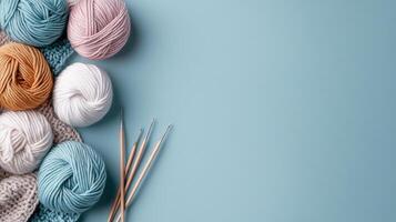 Colorful yarn and knitting needles on blue background photo