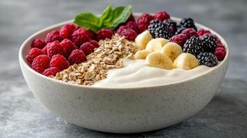 A bowl of yogurt with berries, raspberries and bananas photo
