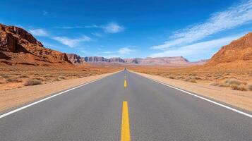 An empty road in the desert with mountains in the background photo