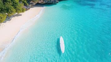 A white boat is floating in the ocean near a beach photo