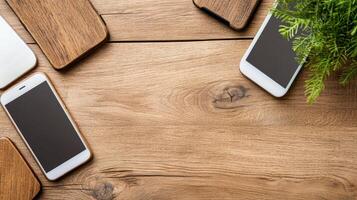 Three cell phones and a laptop on a wooden table photo