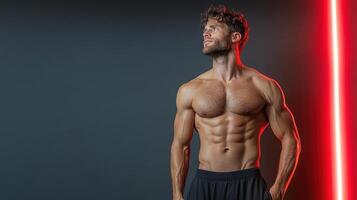 A shirtless man standing in front of a red light photo