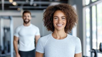 A woman is smiling while standing in front of a man in a gym photo