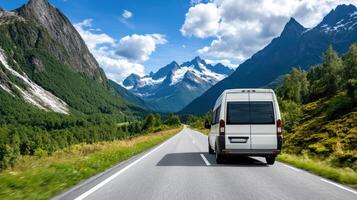 A white bus driving down the road in front of mountains photo