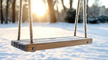 A wooden swing is in the snow photo