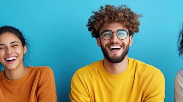 Three people laughing and smiling in front of a blue background photo