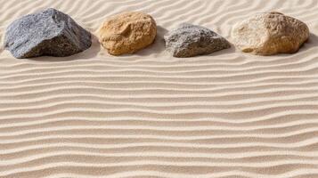 Three rocks in the sand with a wavy pattern photo