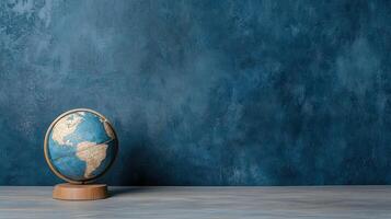 World globe on wooden stand against blue wall concept of world travel and travel concept photo