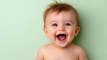 A baby is laughing and smiling in front of a green background photo