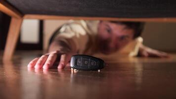 Man reaching for car keys underneath furniture video