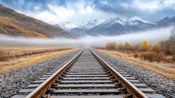 A railroad track in the mountains with fog photo