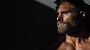 A shirtless man with no shirt on against a wall photo