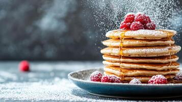 Stack of pancakes with raspberries and powdered sugar photo