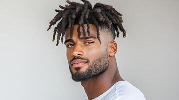 A man with dreadlocks and a white shirt photo
