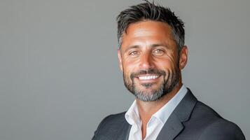A man with a beard and a suit smiling photo