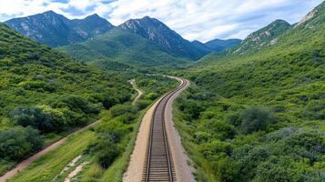 A train track in the mountains with green trees photo