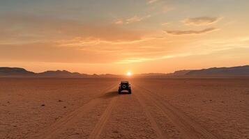 A vehicle is driving through the desert at sunset photo