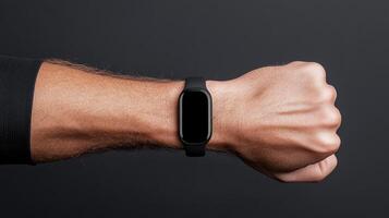 A man holding a black smart watch on his wrist photo