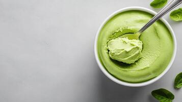 Green ice cream with spoon on white background photo