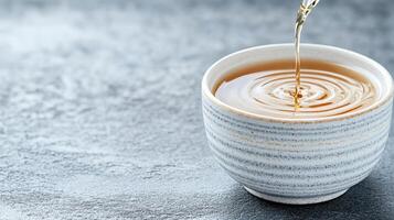 A cup of tea being poured into it photo