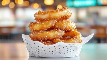 A stack of onion rings sitting on top of a paper cup photo