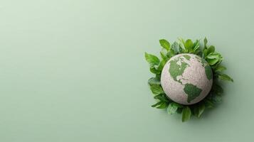Earth globe with green leaves on a green background photo