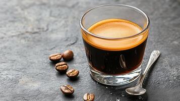 A glass of coffee with beans and a spoon photo