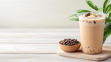An iced coffee with a potted plant on a wooden table photo