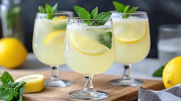 Two glasses of lemonade with mint leaves on a cutting board photo