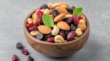 Nutty mix of dried fruits and nuts in a wooden bowl photo