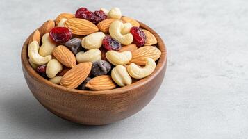 Nutty mix in a wooden bowl on a gray background photo